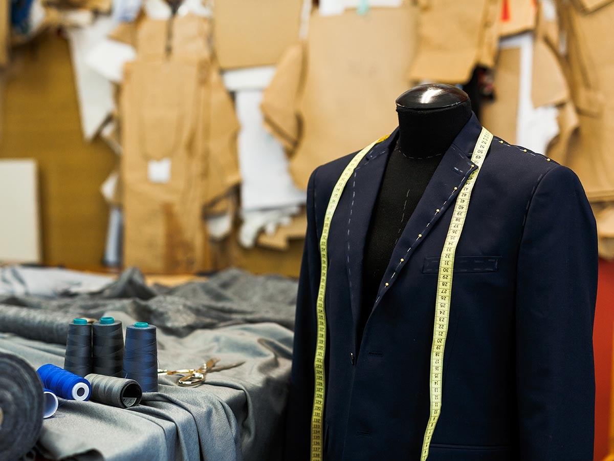 Suit being tailored at clothing store.