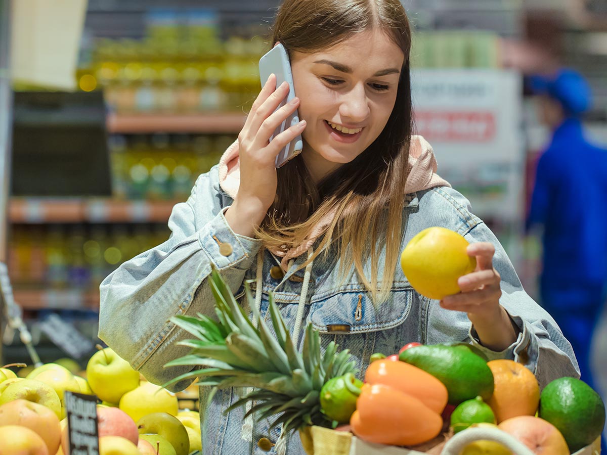 Woman looking at fruits and vegetables at grocery store.