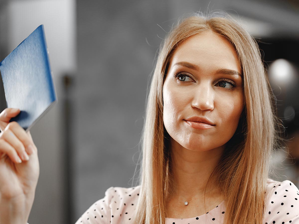 Woman holding her ID at liquor store.