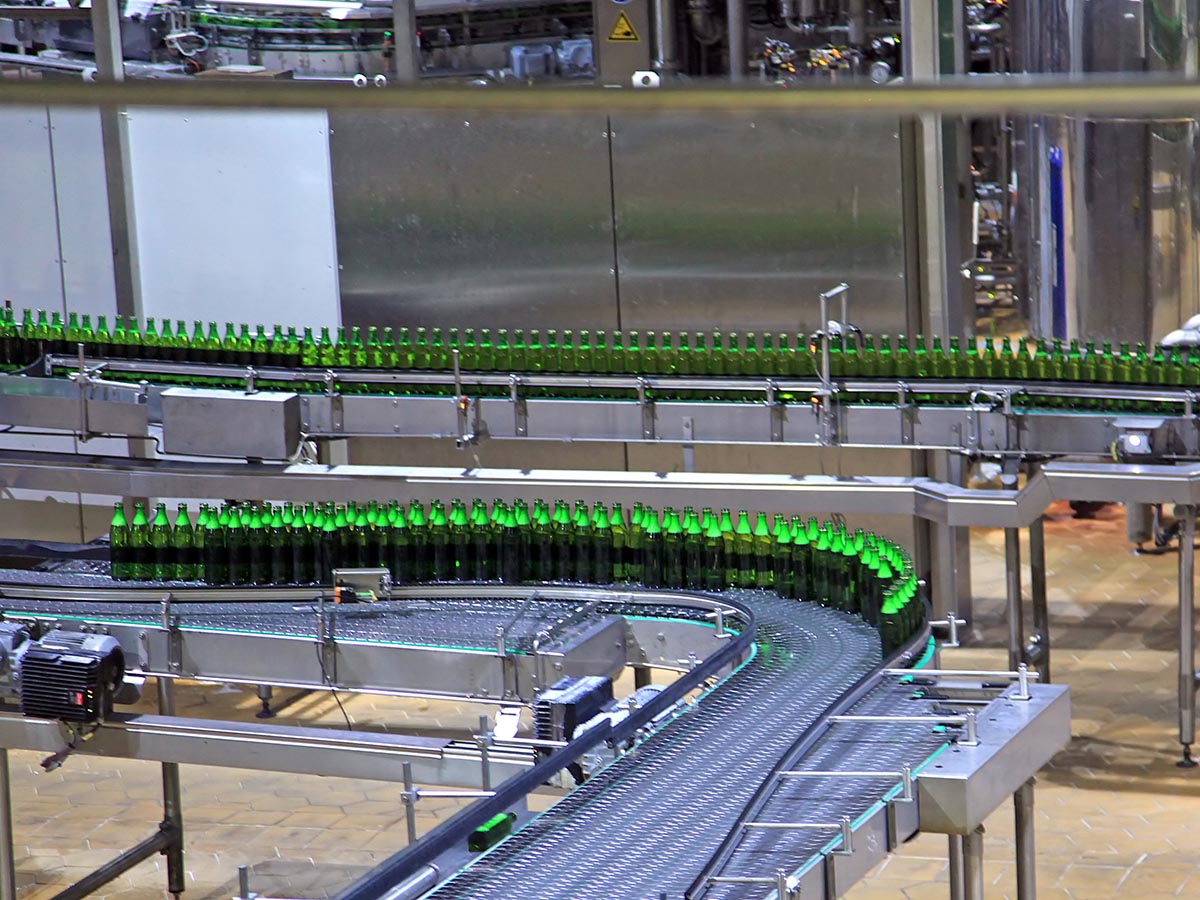 Bottles on conveyor belt at manufacturing plant.