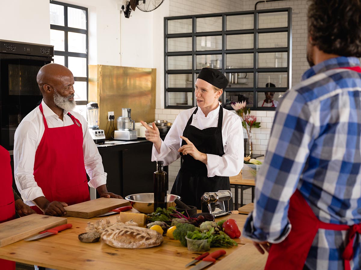 Head chef instructing other chefs or giving cooking lessons.