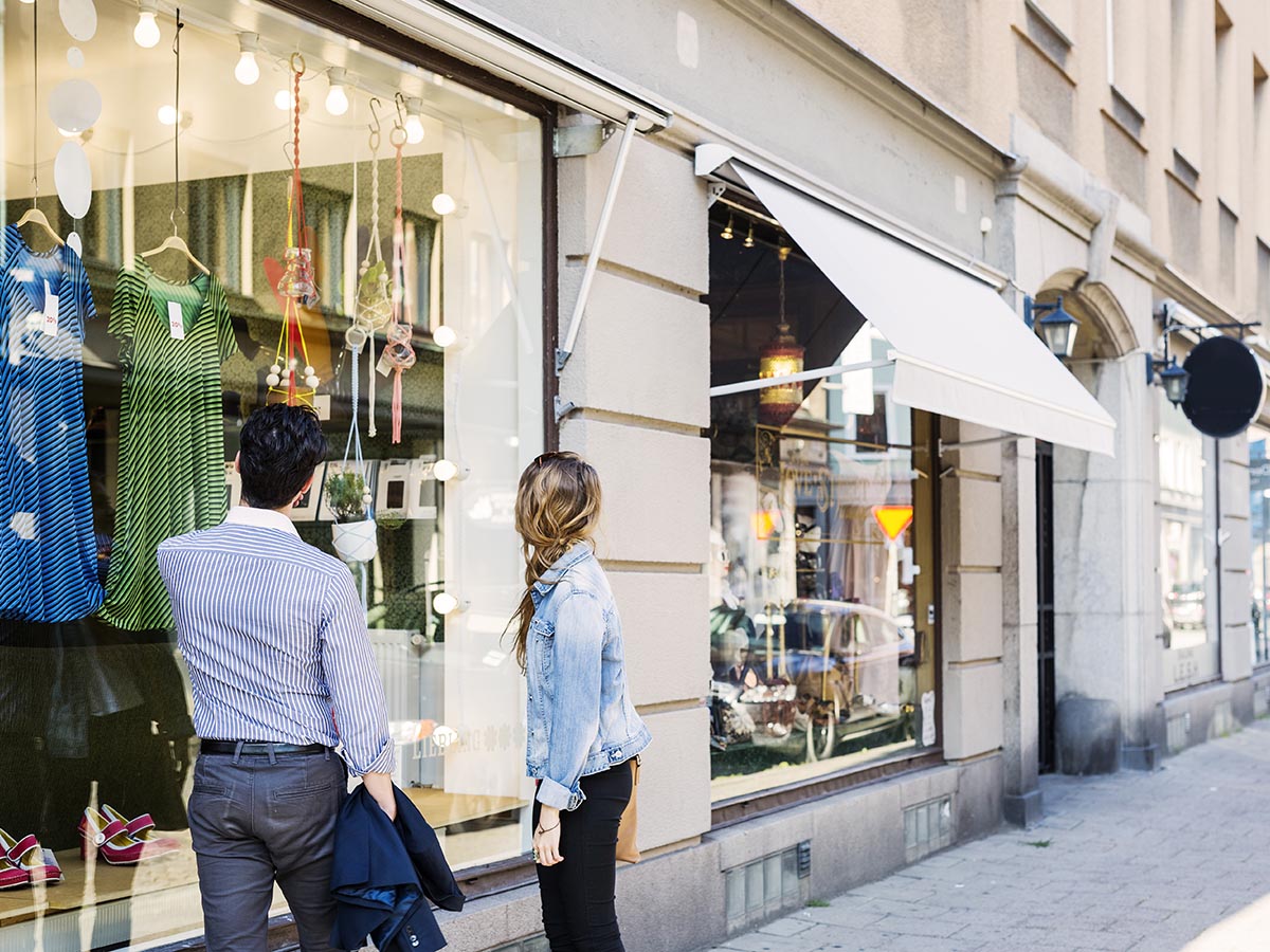 A man and women standing outside a store window.